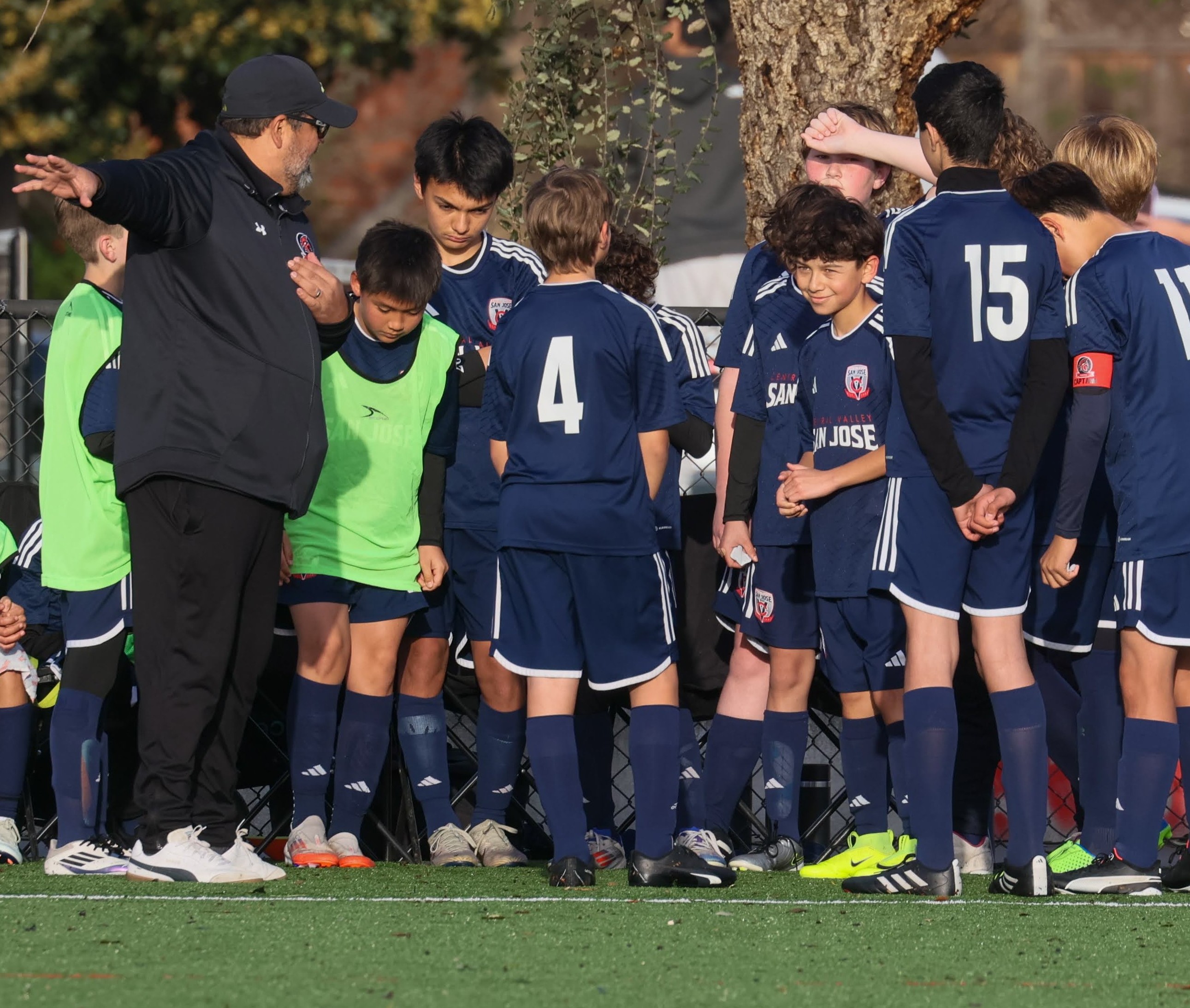 Coach speaking with SPARTANS players during a team instruction moment